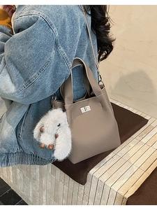Taupe pebbled leather bucket bag with silver twist lock and plush rabbit charm details