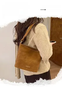 Nahaufnahme der braunen Retro-Beuteltasche mit matter Wildlederstruktur und Logo