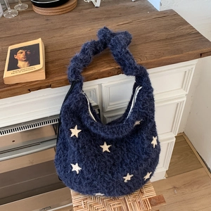 Detail of plush navy hobo bag with white star appliques and silver metal zipper closure