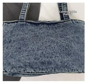 Close-up of washed denim crossbody bag featuring contrast stitching and soft fabric