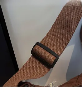Détail de la bandoulière en nylon réglable avec boucle sur un sac en toile matelassé