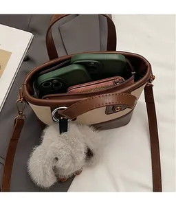 Détail du sac seau bicolore montrant l'intérieur spacieux pour portables et portefeuilles