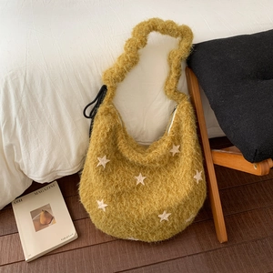 Detail of yellow plush shoulder bag with white star patches and soft fuzzy texture