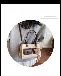 Detail of vintage square bag with flap pockets, contrast colors and plush bear charm