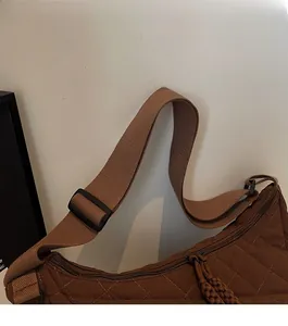 Détail de la bandoulière réglable en tissu marron sur le sac cabas matelassé café