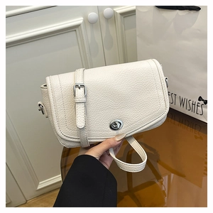 Detalle de bolso bandolera blanco en cuero granulado con cierre de broche plateado