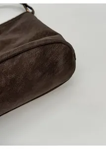 Detailaufnahme des verstärkten Bodens der dunkelbraunen Ledertasche mit feinen Nähten