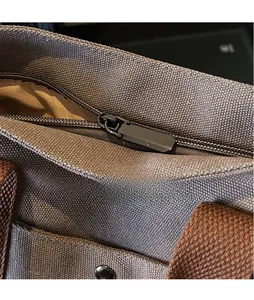 Macro detail of high-quality smooth metal zipper on grey canvas tote shoulder bag