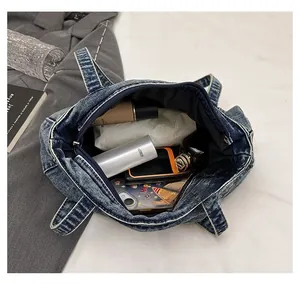 Blue denim tote bag showing spacious interior with phone and cosmetics for daily use