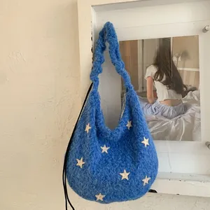 Detail of blue plush shoulder bag with white stars and ruched handle texture