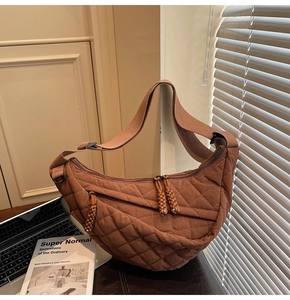 Détail d'un sac à bandoulière matelassé marron avec tirette de fermeture éclair nouée