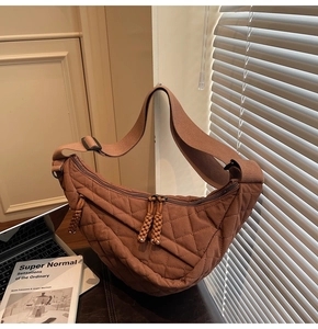 Détail de la sacoche demi-lune marron matelassée avec tirette tressée et sangle