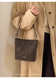 Details der dunkelbraunen Schultertasche aus mattem Leder mit Vintage-Textur und Logo