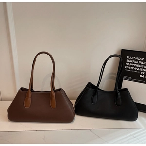 Close-up of litchi texture leather tote bags in coffee and black with long handles