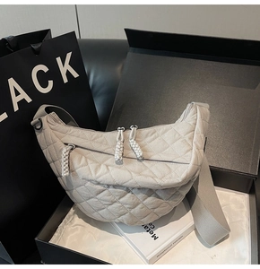 Détail du sac matelassé gris clair avec tirettes tressées et large bandoulière