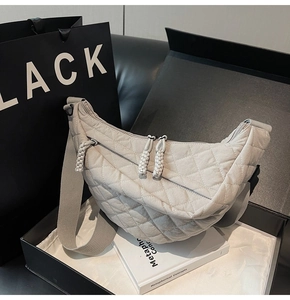 Détail du sac croissant matelassé gris clair avec coutures losanges et tirette tressée