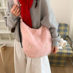 Detailed close-up of pink plush hobo bag featuring white star patches and soft drawstring design