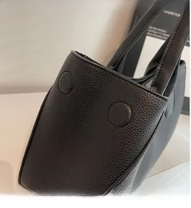 Detail shot of black tote bag showing pebble leather texture and soft material