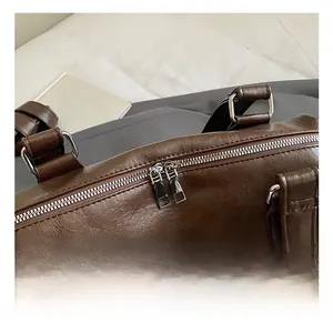 Close-up of textured brown leather bag with silver metal hardware and smooth dual zippers