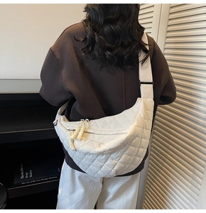 Vue détaillée du dos d'un sac à bandoulière matelassé blanc porté par un modèle