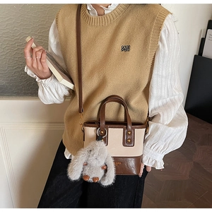 Dettaglio della mini borsa a secchiello retrò con design color-block e charm a coniglio