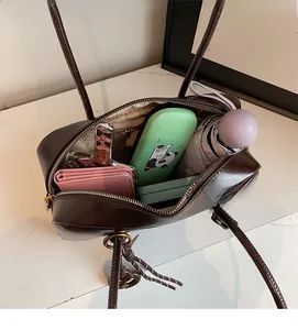 Interior view of chocolate brown crossbody bag showing large storage capacity and zipper