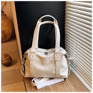 Detail of cream white leather tote bag showing lychee grain texture and dual zipper design
