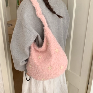 Detail of pink plush shoulder bag with white star patches and soft faux fur texture