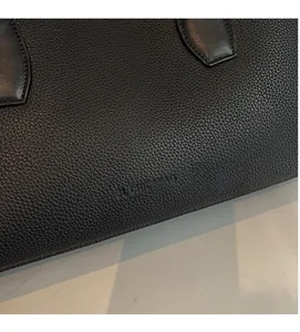 Detail shot of black litchi texture leather tote bag featuring embossed JL CHIC&BAG logo