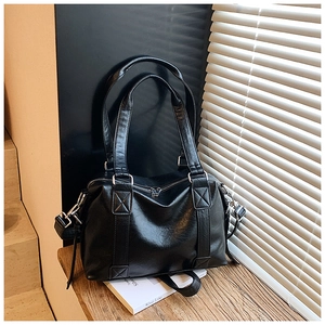 Detailed view of a black retro glossy leather tote with silver hardware and natural texture