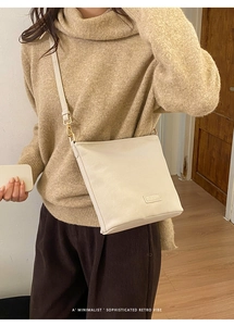 Minimalistische beige Umhängetasche kombiniert mit Herbstoutfit in gemütlicher Atmosphäre
