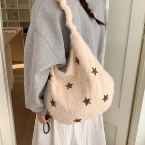 Detail view of cream plush hobo bag with brown star embroidery and wide strap