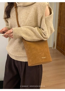 Detailansicht der braunen Retro-Ledertasche mit Logo und minimalistischer Textur