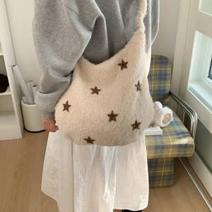 Detail of plush cream shoulder bag with brown star embroidery and soft wool-like texture