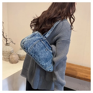 Detailed close-up of dark blue washed denim fabric on this trendy crescent shoulder bag