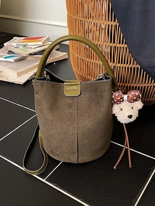 Braune Wildleder Beuteltasche mit olivfarbenen Ledergriffen und Plüschbär-Anhänger