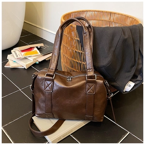Detailed view of dark brown Boston bag with retro PU leather and silver double zipper