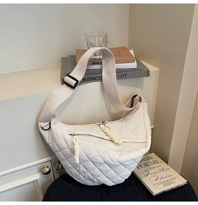 Vue détaillée du sac demi-lune crème matelassé avec double fermeture et bandoulière