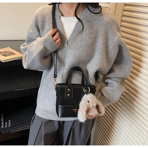 Détail du sac seau noir avec lettrage doré et pendentif lapin en peluche doux
