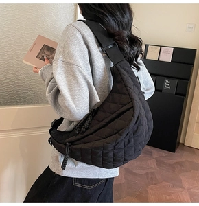 Détail du sac bandoulière matelassé noir avec forme de lune et bandoulière réglable