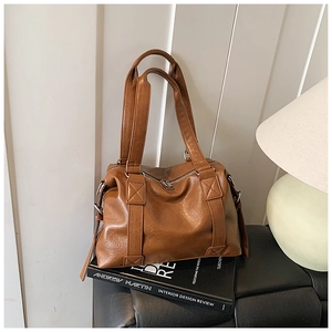 Detailed close-up of retro caramel brown faux leather tote bag with silver zippers