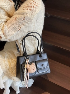 Chic black matte shoulder bag with dual front pockets and cute teddy bear charm