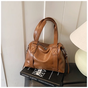 Detailed view of the brown PU leather tote bag handle and top zipper closure design