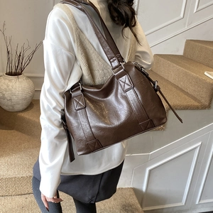 Detail of dark brown vintage tote with reinforced wide handle and oil wax leather texture