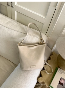Schicke beige Leder-Beuteltasche auf modernem Sofa mit stilvollem Wohninterieur-Hintergrund