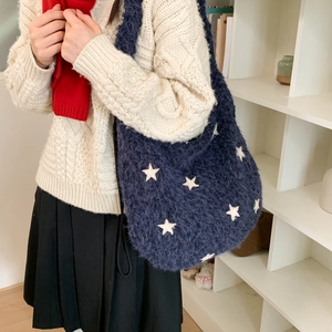 Detail of navy knit shoulder bag with white star patterns and large capacity design