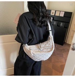 Détail du sac croissant matelassé crème avec tissu en nylon et bandoulière réglable