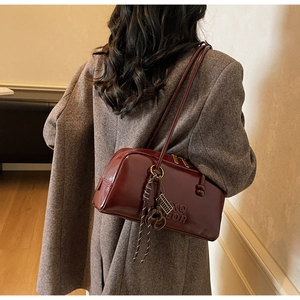 Detail showing deep red oil leather finish and XQ COLOR embossed texture on Boston bag