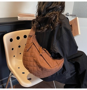 Sac croissant marron matelassé avec bandoulière large dans un décor élégant