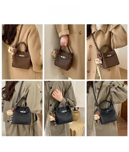 Detail showing high-quality lychee grain leather bucket bag with teddy bear charm accessory